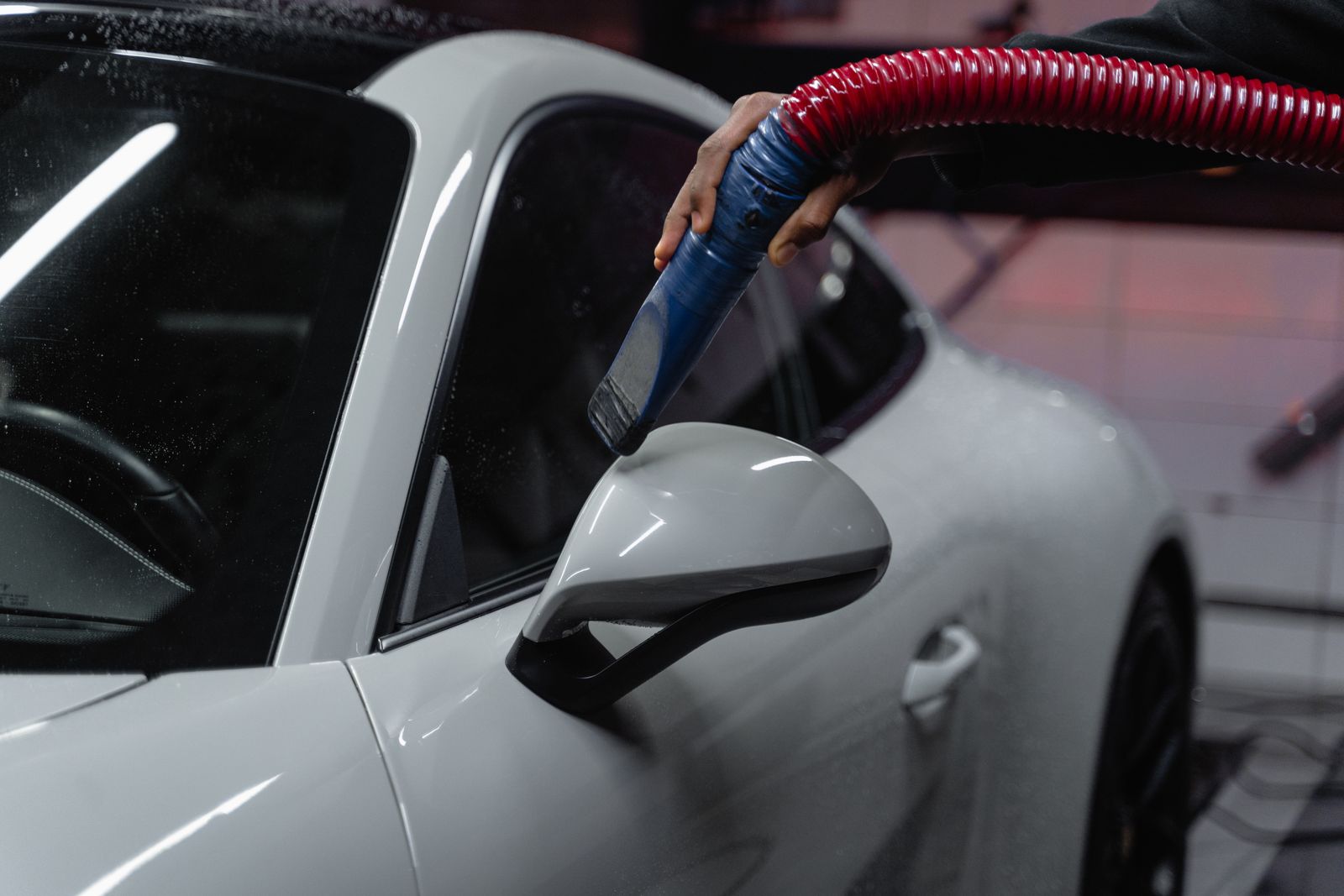 Detailer vacuuming a sports car